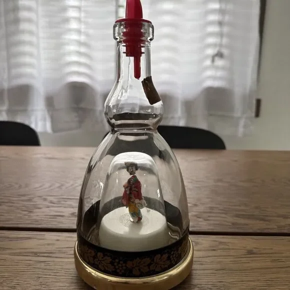 vintage Lucas Bols musical liqueur bottle featuring a  rotating geisha Inside