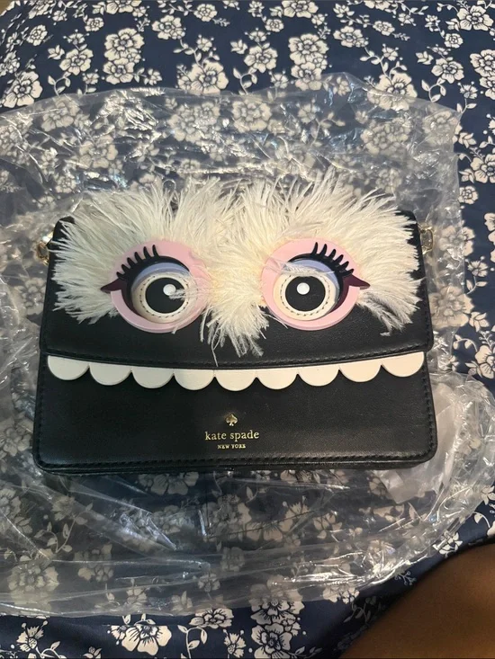 kate spade black novelty monster crossbody with white fur and pink eye accents