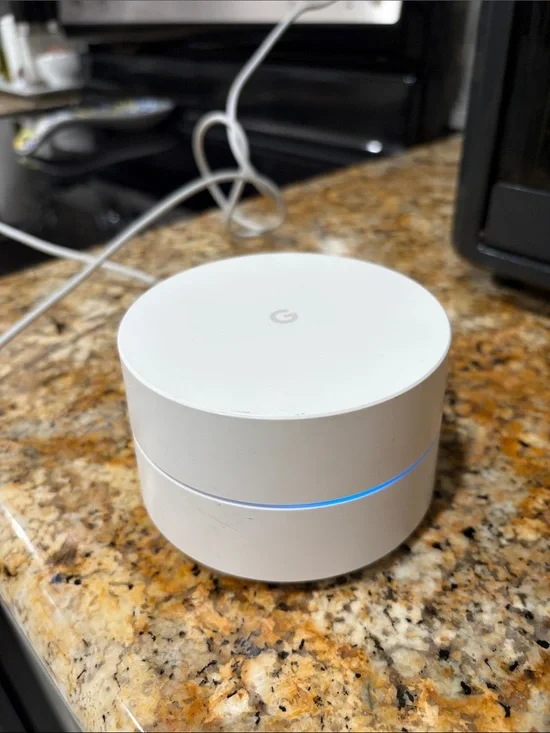 Google mesh Wi‑Fi puck in white with blue LED