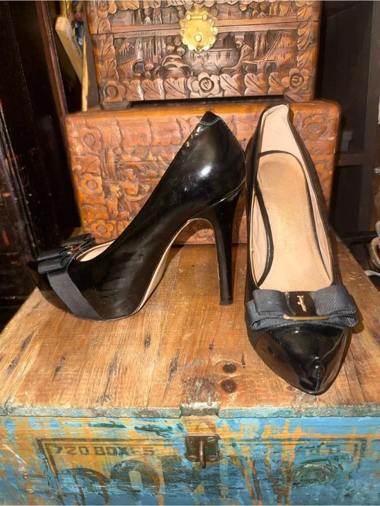 Salvatore Ferragamo Black Patent featuring iconic gold plate & grosgrain bow