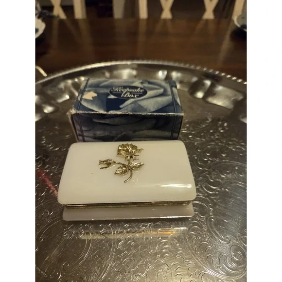 vintage white hinged trinket box features a polished finish with a delicate,...
