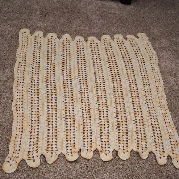 Handmade yellow and white crocheted‎ baby blanket with a scalloped edge
