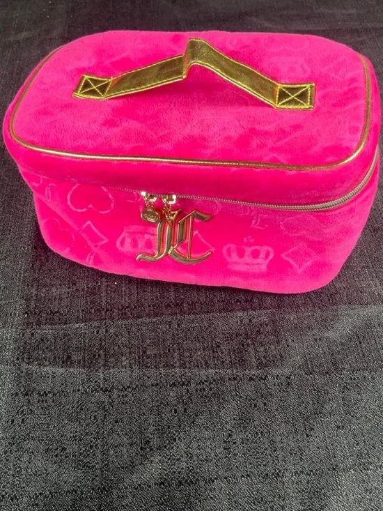 Pink Juicy Couture velvet makeup bag with gold accents and repeating monogram pa