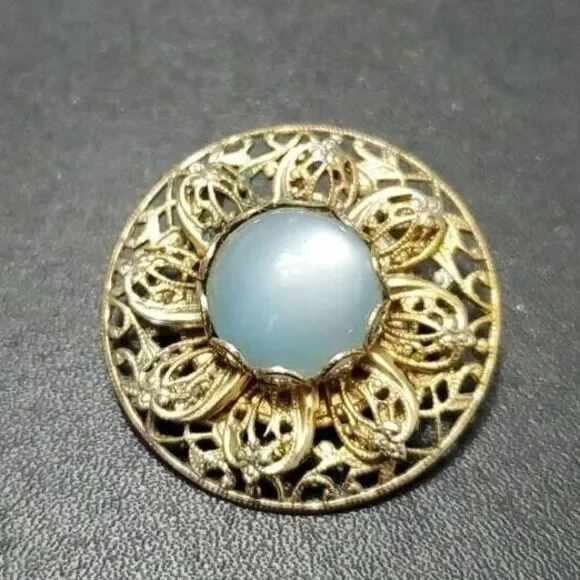 Vintage gold tone round brooch with blue