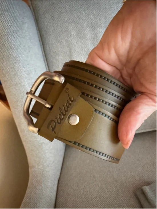 Pielini belt features a distinct studded border design and a metallic buckle.