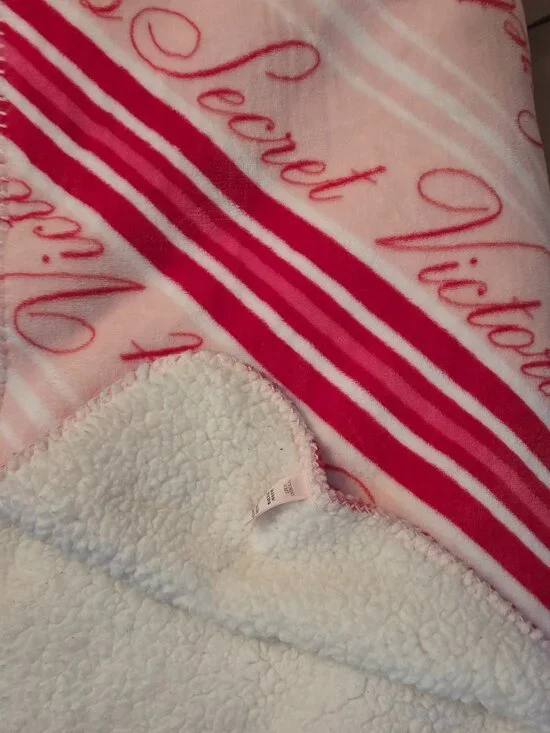 Victoria's Secret Cozy Plush Blanket features cozy white sherpa fleece on the re