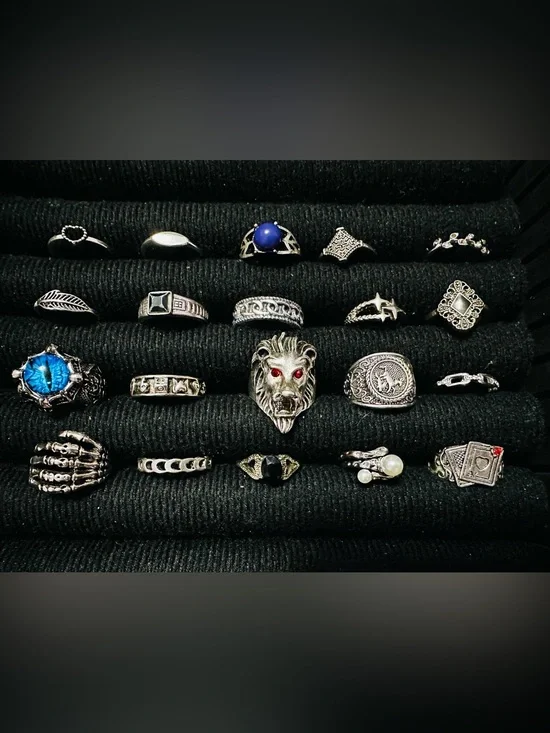 Assorted rings, including lion head, eye, and playing card designs.