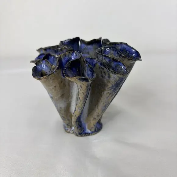 Decorative ceramic vase featuring a unique, organic ruffled shaped blue-glazed