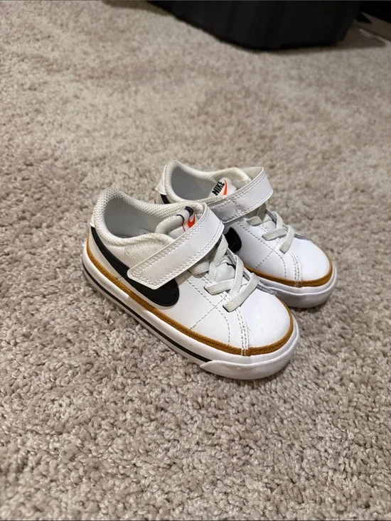 Nike Kids White Sneakers with Black Swoosh and Gold Accent
