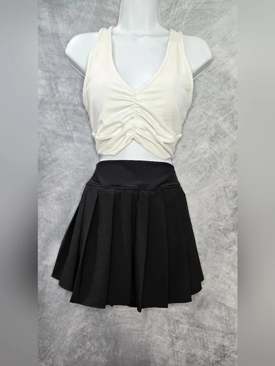 ALO Yoga Wild Thing Bra paired with a black pleated skirt