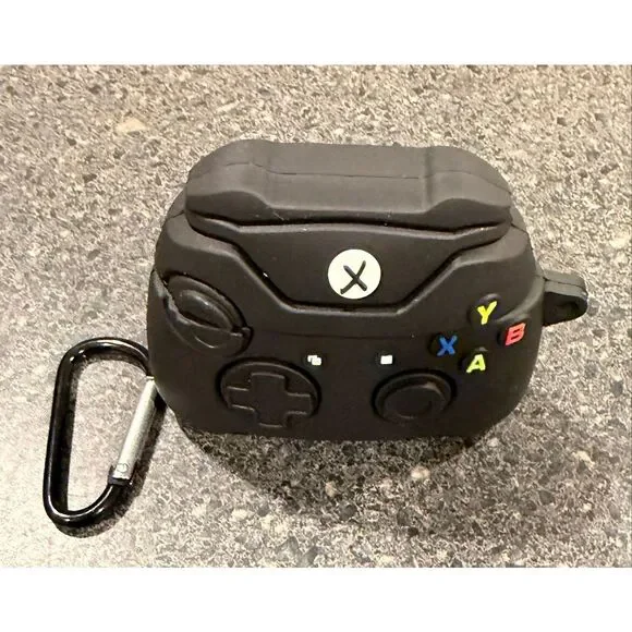Silicone protective case for Apple AirPods, designed to resemble a black Xbox co