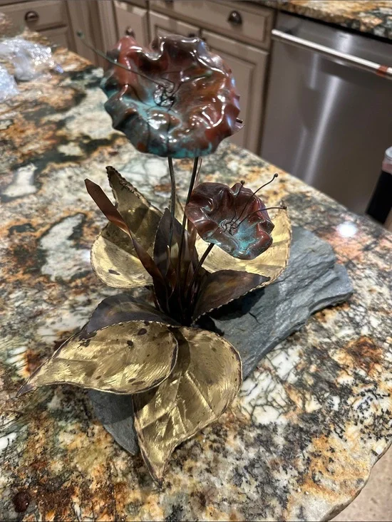 These are vintage Brutalist mixed metal floral sculptures mounted on slate bases