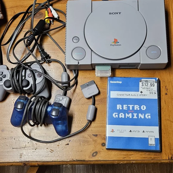 Sony PlayStation One Console with Gray and Blue Controllers And Grand Theft Auto