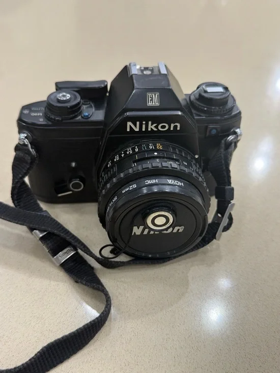 Nikon Black 35mm SLR Camera with Attached Lens and Strap