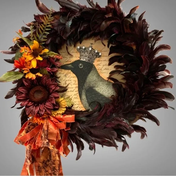 Dark red and black feather wreath with fall floral and a crowned crow center