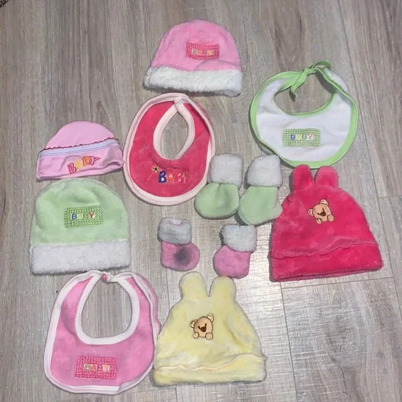 Colorful bundle of plush baby bibs, hats, and mittens
