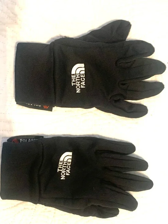 These north face gloves are mostly black, made with Polartec. Size XS
