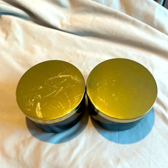 Two black jars with gold lids