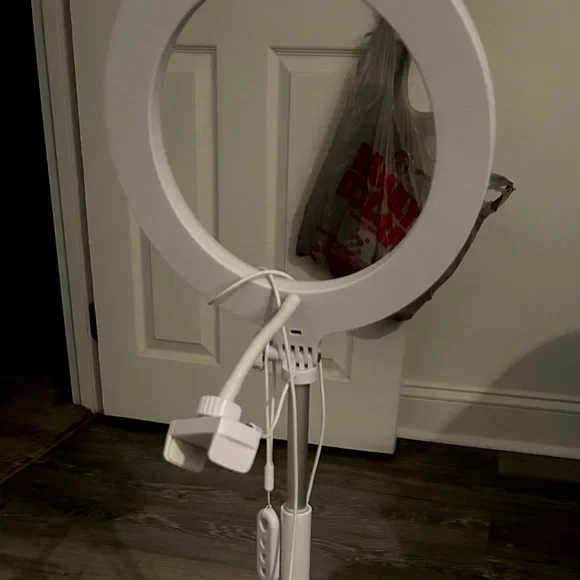 This is a standing ring light with a phone holder accessory with a remote also