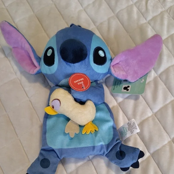 Disney Stitch Holding A Duck Soother Plush With Squeaker And Crinkle Material.