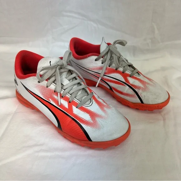 Puma kids turf shoes in white, bright coral and black.