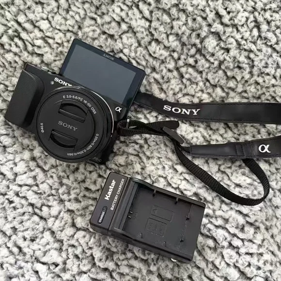 Sony Black Mirrorless Camera with Black Neck Strap and Battery Charger