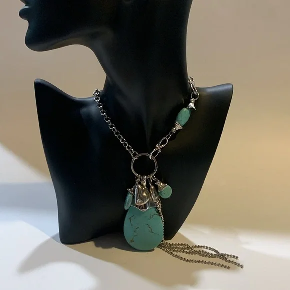 Silver tone and turquoise necklace with oversized pendant and charms.