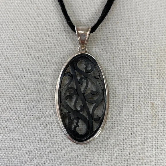 Carved wood pendant 925 on black cord