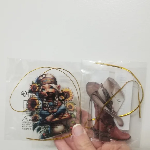 2 ornaments with gold strings- 1 cowboy themed and 1 hippie