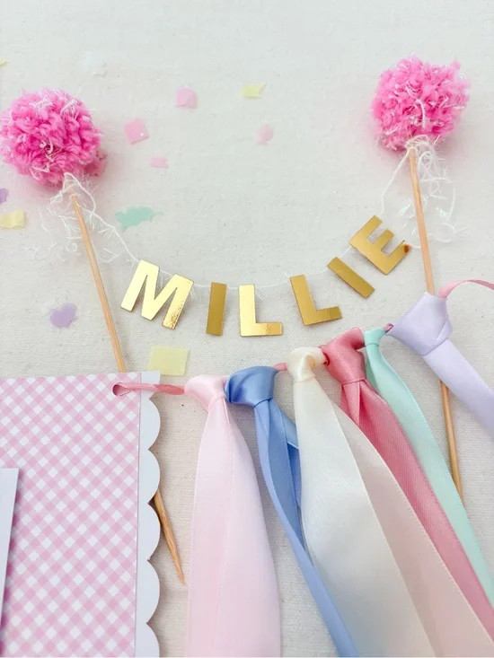 Personalized Gold 'Millie' Party Banner with Pink Pom-Poms and Pastel Ribbons