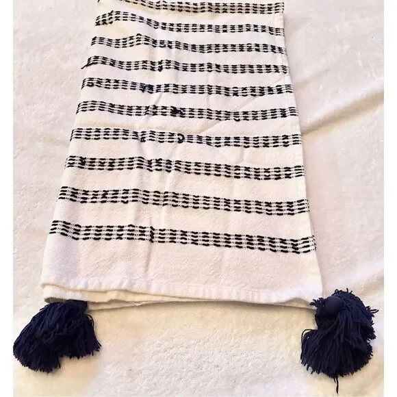 Navy and white stitched towel with Pom Pom’s