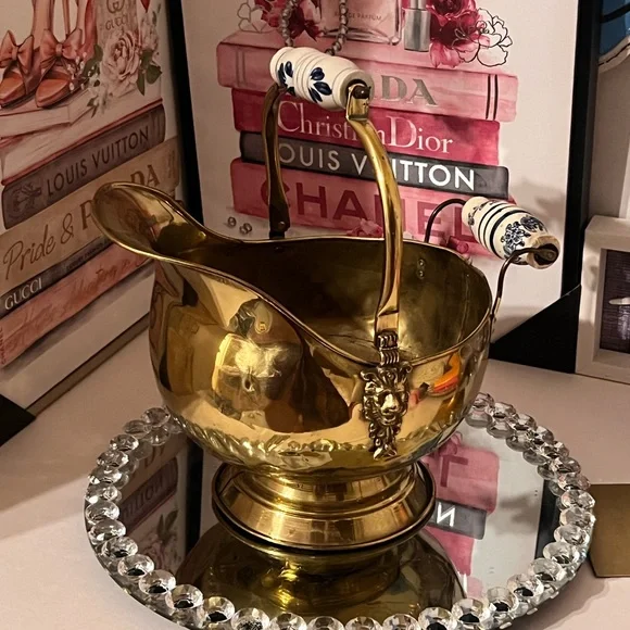 Vintage brass scuttle bucket with a blue and white ceramic handle and lion head