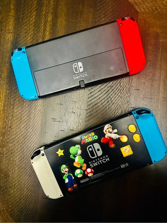 Nintendo Switch Consoles with Red, Blue, White Joy‑Con and Super Mario Backplate
