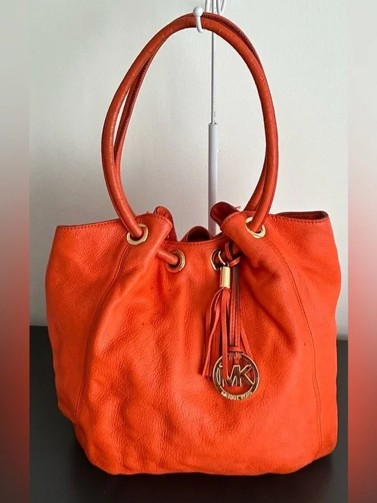 Michael Kors Orange Pebbled Leather Drawstring Tote tassel shoulder bag