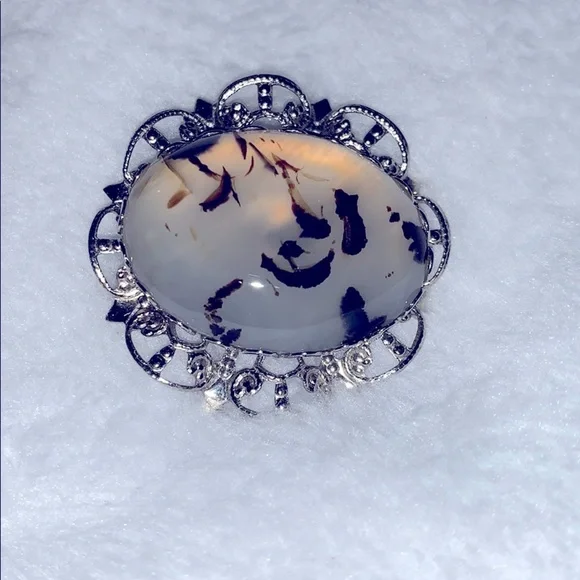 Translucent w/ black accents stone in a silver pin