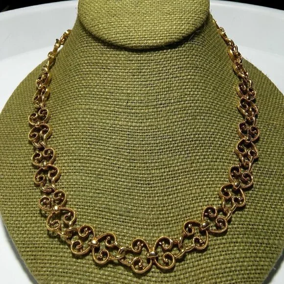 Women`s gold tone swirl necklace. 19 inches long.