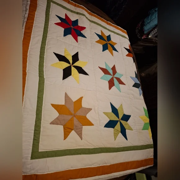 This colorful handmade quilt features a unique 8-point star pattern