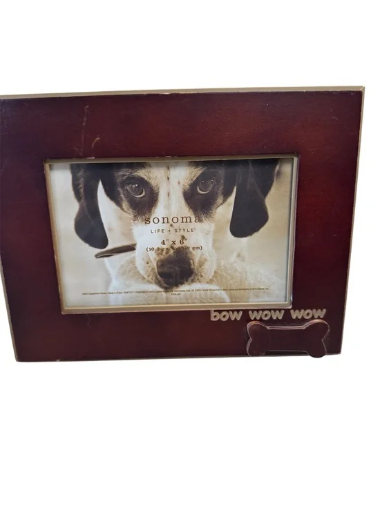 A Sonoma Life & Style brown wood picture frame with dog bone and bow wow wow