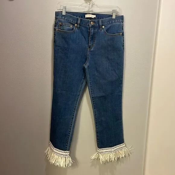Tory Burch Connor jeans in medium allover stone wash. Cropped. Raffia fringed