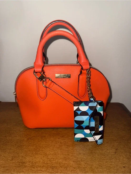 Trina Turk Dome Satchel Handbag in a vibrant, sunset orange.