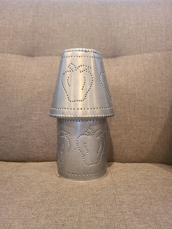 Primitive Irvin's Punched Tin Lamp featuring a distinct apple