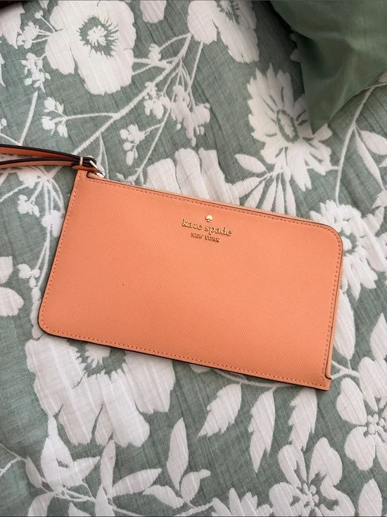 kate spade peach/orange leather wristlet with gold logo