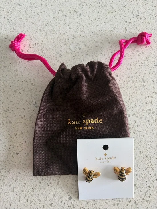 kate spade gold and black bee stud earrings with brown pouch and pink drawstring