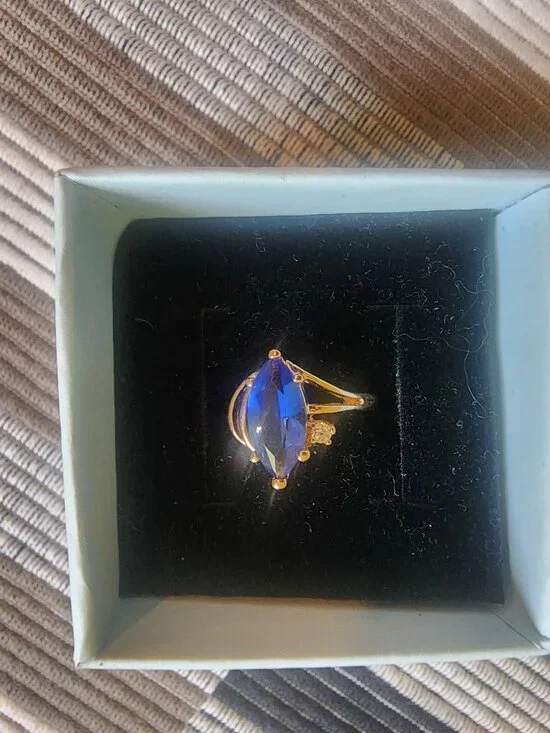 Gold colored band w/ ocean blue stone. Size 5.5
