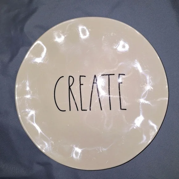 A Rae Dunn plate with the word CREATE in the middle. It's 8