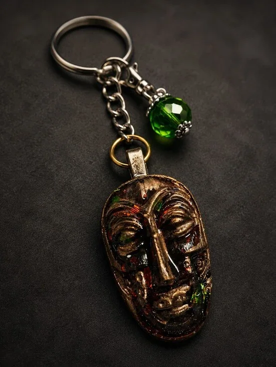 Artisan Bronze Mask Keychain with Green Crystal Accent