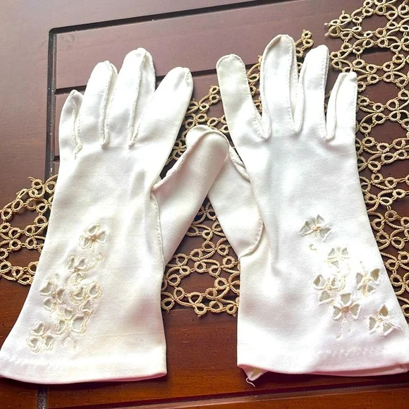 Beautiful delicate vintage white gloves with floral accents.