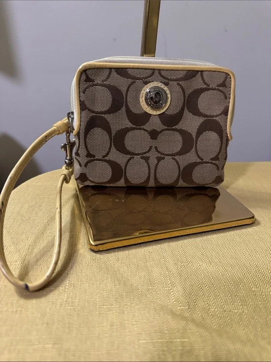 This is a Coach Poppy Signature Wristlet featuring the iconic C pattern