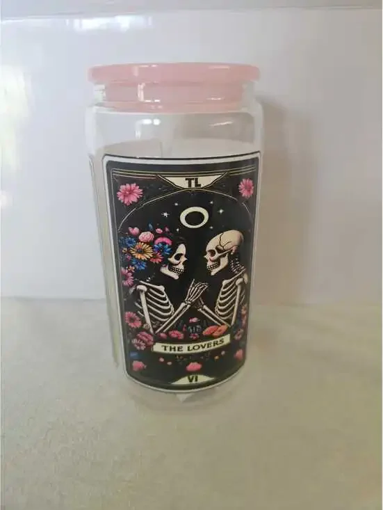 16 oz glass cup with acrylic Lid. Featuring skeletons and flowers.