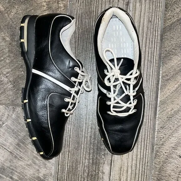 Nike Air TAC black leather golf shoes, sports performance.